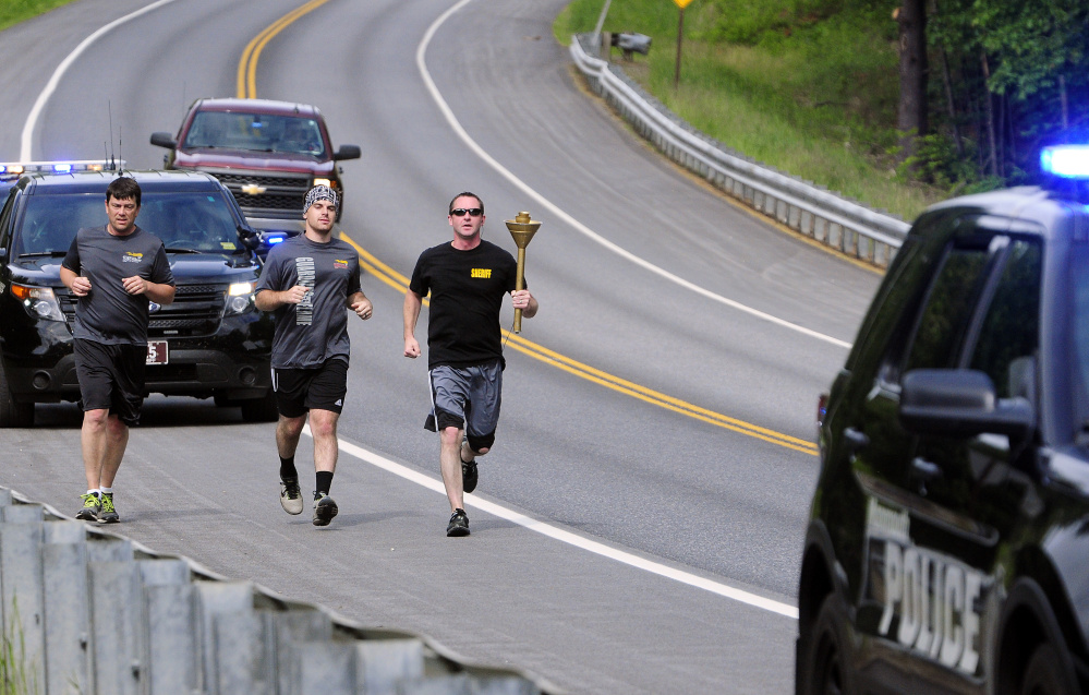 Monmouth Police Chief Kevin Mulherin, left, Mitch Cobb and Kennebec County Sheriff's Deputy Phil Lynch run the Law Enforcement Torch Run for the Special Olympics on Thursday along U.S. Route 202 in Monmouth.