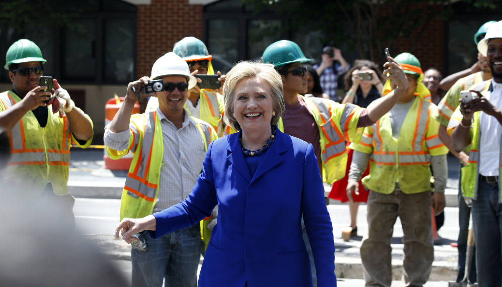 Hillary Clinton is all smiles greeting workers after a stop at the Uprising Muffin Co. in Washington, D.C., on Friday, a day after securing President Obama's endorsement as well as that of Vice President Joe Biden and Sen. Elizabeth Warren.