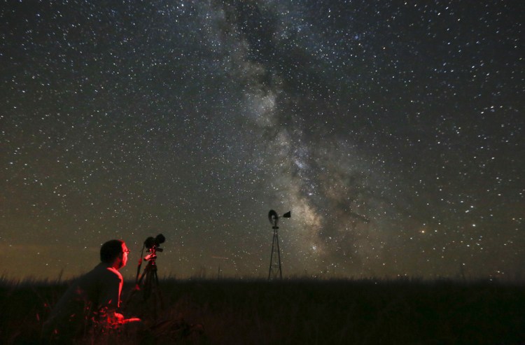 A man photographs the sky near Callaway, Neb., in July 2014, on a night when the Milky Way was visible to the naked eye. Light pollution obscures the Milky Way in much of the world.