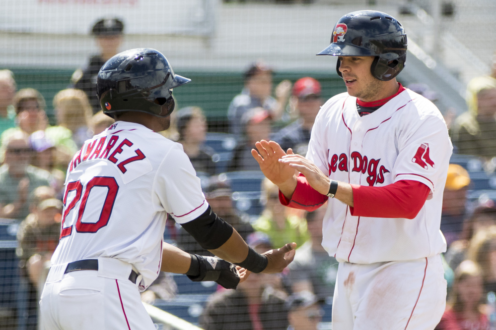 Aneury Tavarez, left, and Danny Bethea celebrate after scoring on a single by Ryan Court in the seventh inning Sunday, helping the Sea Dogs pull away for a 7-1 win against Richmond.