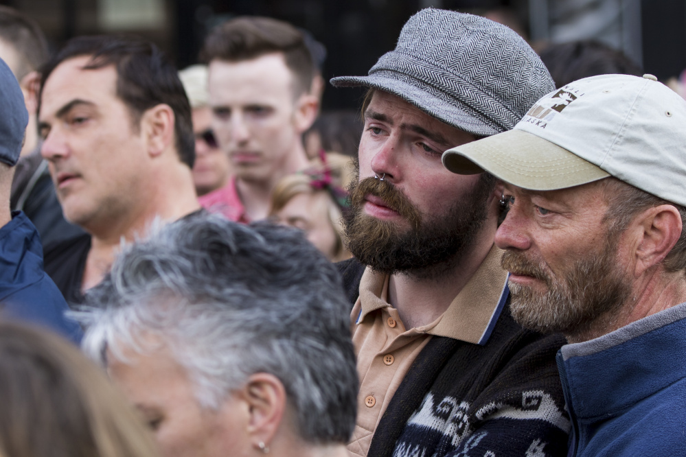 Couple Kevin Knieriem and Tim Mason, far right, embrace during Sunday's vigil in Monument Square to remember victims of the mass shooting in Orlando.