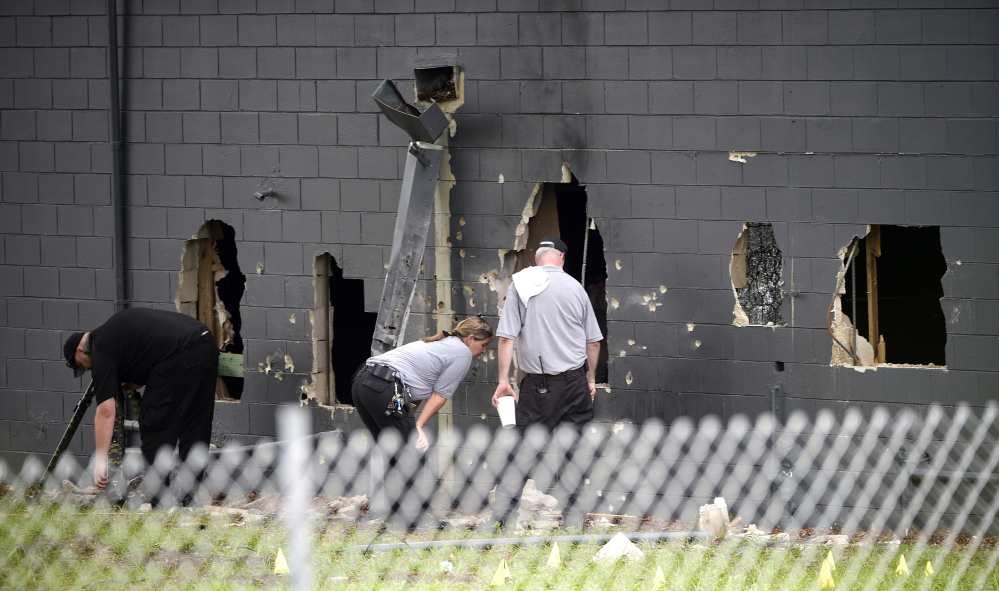 Police officials investigate the back of the Pulse nightclub Monday, a day after Omar Mateen killed 49 people and wounded more than 50 others at the nightclub in Orlando.