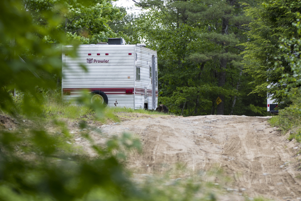 A camper sits parked at 540 Ossipee Trail in Limington, where Maine State Police investigated a homicide Sunday. The Evidence Recovery Team van is behind the trees to the right.