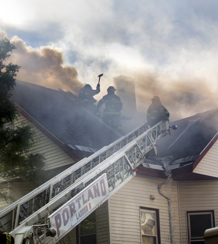 Portland firefighters use ladders to access the roof while fighting a fire at 15 Sherman St. in Portland. 