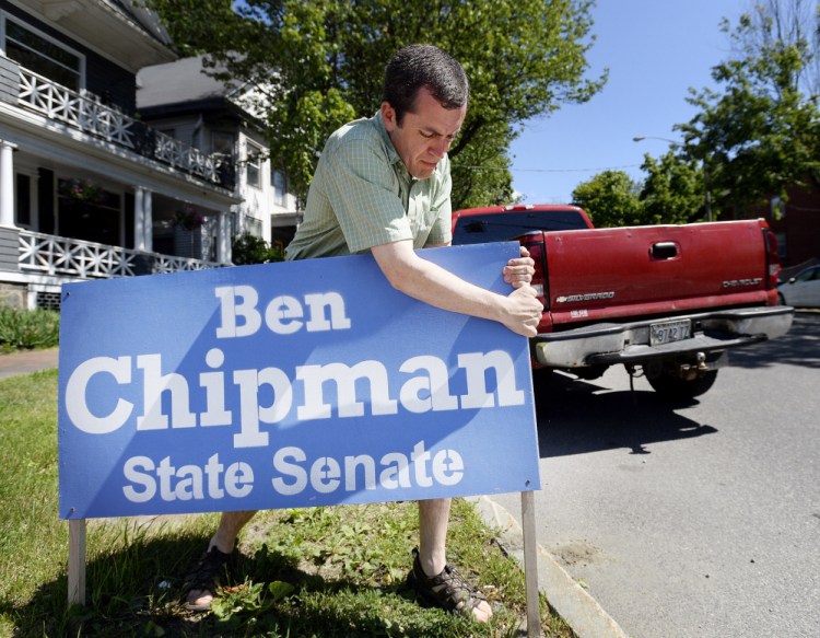 State Rep. Ben Chipman, who won the Democratic primary in Senate District 27 on Tuesday, removes a campaign sign on State Street in Portland. The hard-fought three-way race sparked ethics complaints.