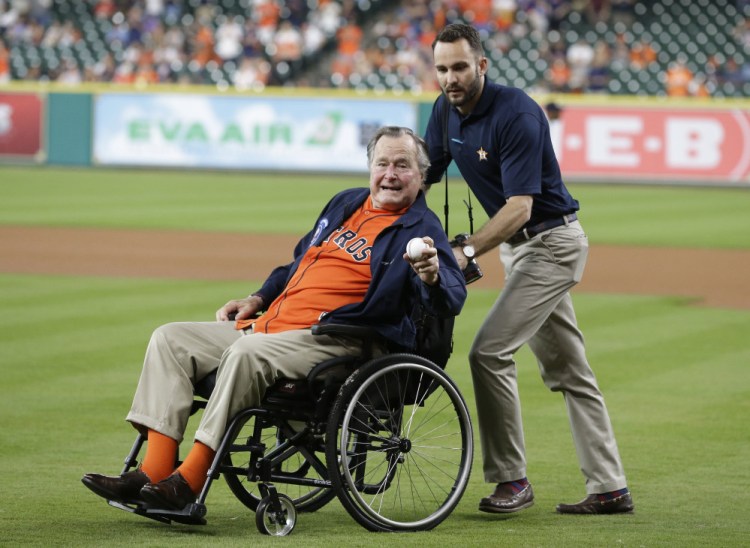 Former President George H.W. Bush is wheeled out to throw out the ceremonial first pitch at a Houston Astros game in April. Bush is spending the summer in Maine.