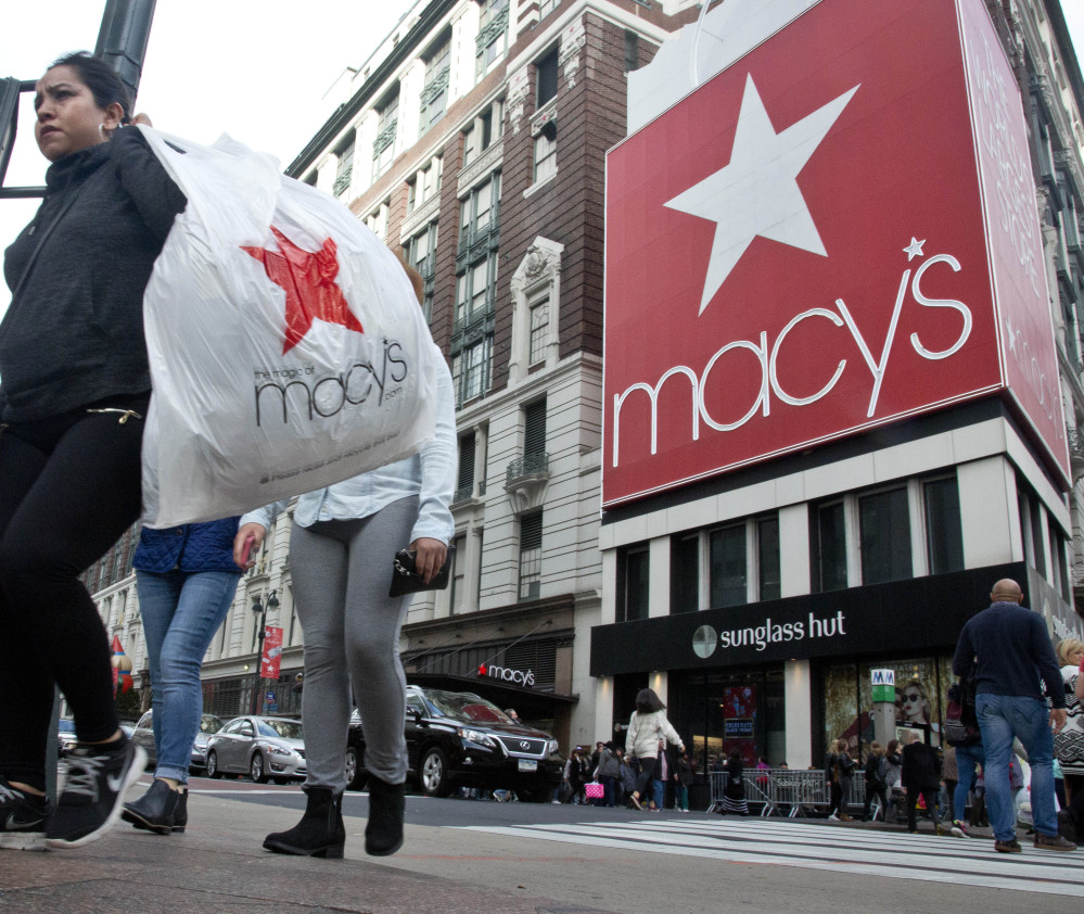 Shoppers carry bags as they cross a pedestrian walkway near Macy's in Herald Square in New York. Macy's said Thursday it has reached a tentative deal with the union representing workers at its flagship store in New York City.