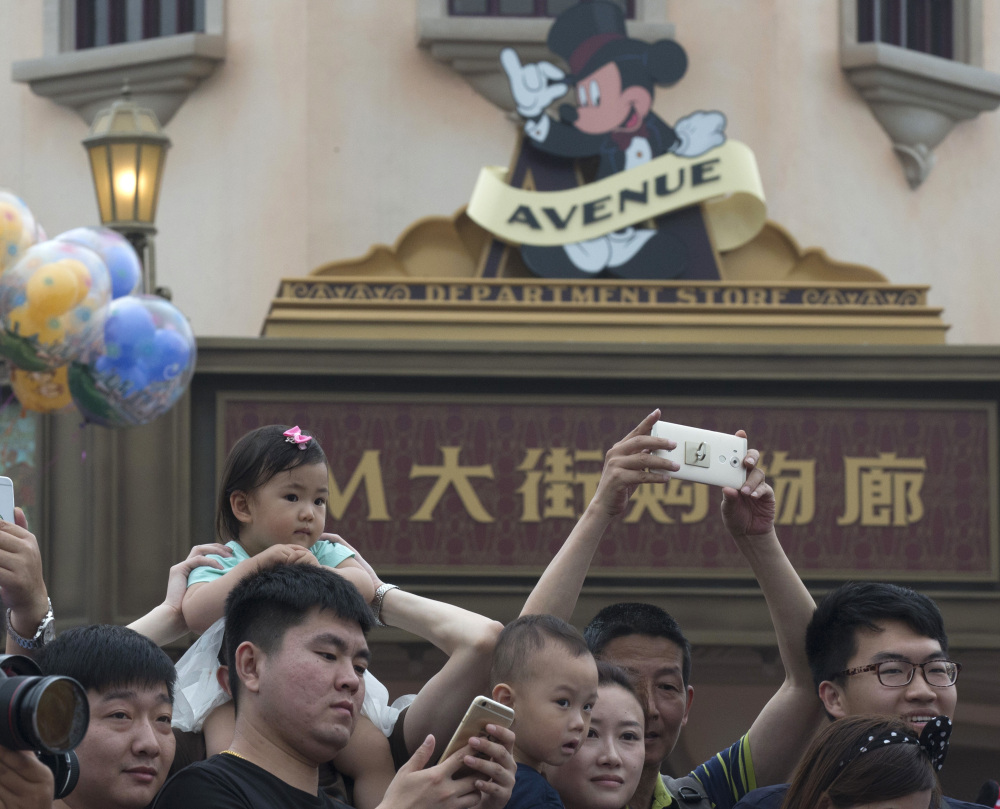 Crowds flock to opening day at Shanghai Disneyland in Shanghai, China, on Thursday. The park plays down some American elements by, for example, dropping Main Street USA and featuring Mickey Avenue and Chinese-themed elements instead.