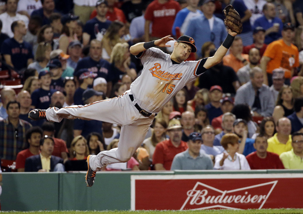 Orioles third baseman Paul Janish leaps to catch a sharp line drive by Boston's Xander Bogaerts in the seventh inning Thursday night at Fenway Park.