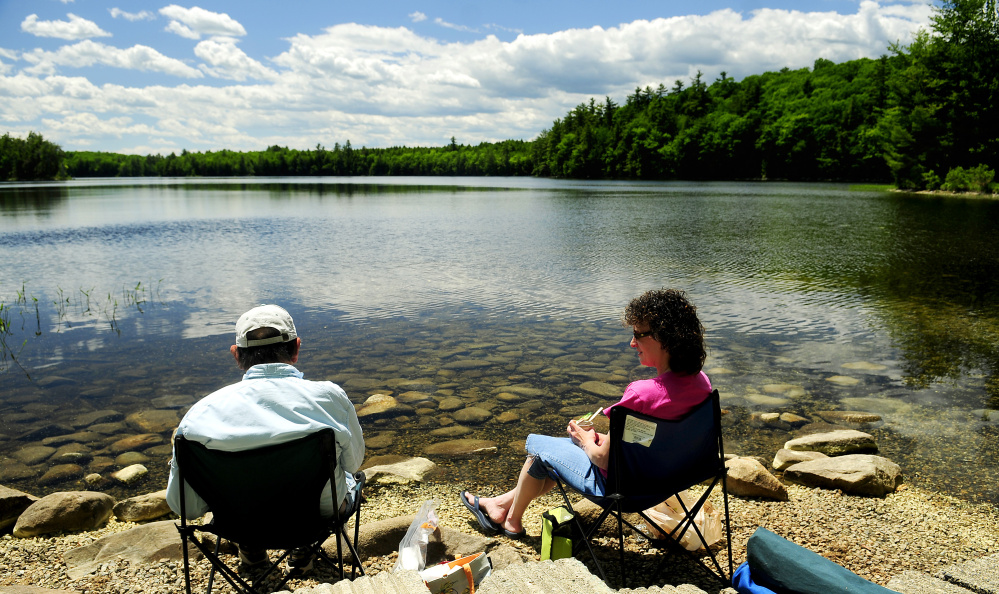 Ray Beaulieu, of Augusta, left, and his daughter Brenda Lapierre, of Poland, have an early Father's Day lunch along the shore in the Jamies Pond Wildlife Management Area on Friday in Hallowell.