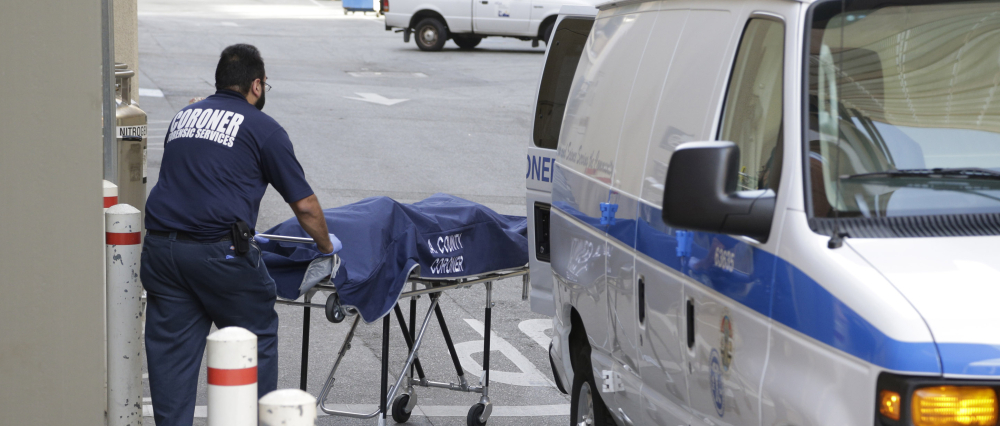 An employee of the county coroner's office removes a body at the scene of what police say was a murder-suicide June 1 at UCLA. On average, there are 33 gun homicides a day in the United States.