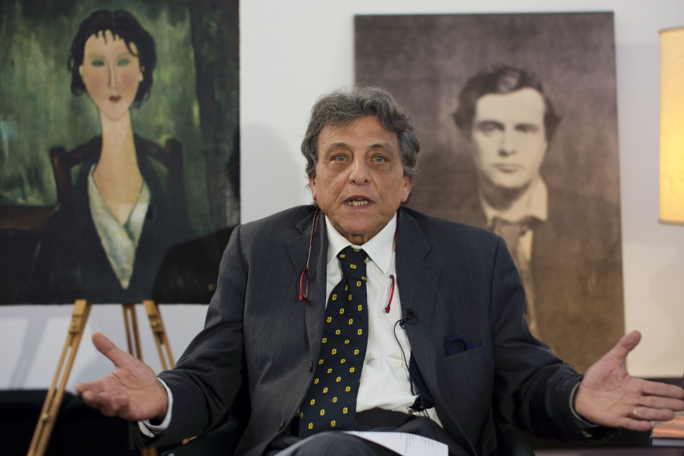 Gennaro Arbia speaks during an interview Friday with the Associated Press in Rome. At left is an unidentified painting which is under investigation to determine whether it is an authentic work by Italian 20th-century master Amedeo Modigliani, portrayed in the photograph at right. Arbia said that his client, a flea market dealer who wishes to remain anonymous, found what he thinks is a Modigliani in June, 2006, resting up against a trash bin at the La Rustica metro stop in Rome's periphery.