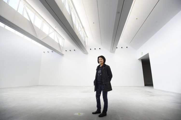 New York architect Toshiko Mori, who has a home on North Haven, poses inside the main gallery of the new Center for Maine Contemporary Art in Rockland. She has enclosed the museum in glass, allowing as much light to enter as possible. A saw-toothed roof filters light into the spacious galleries from above.
