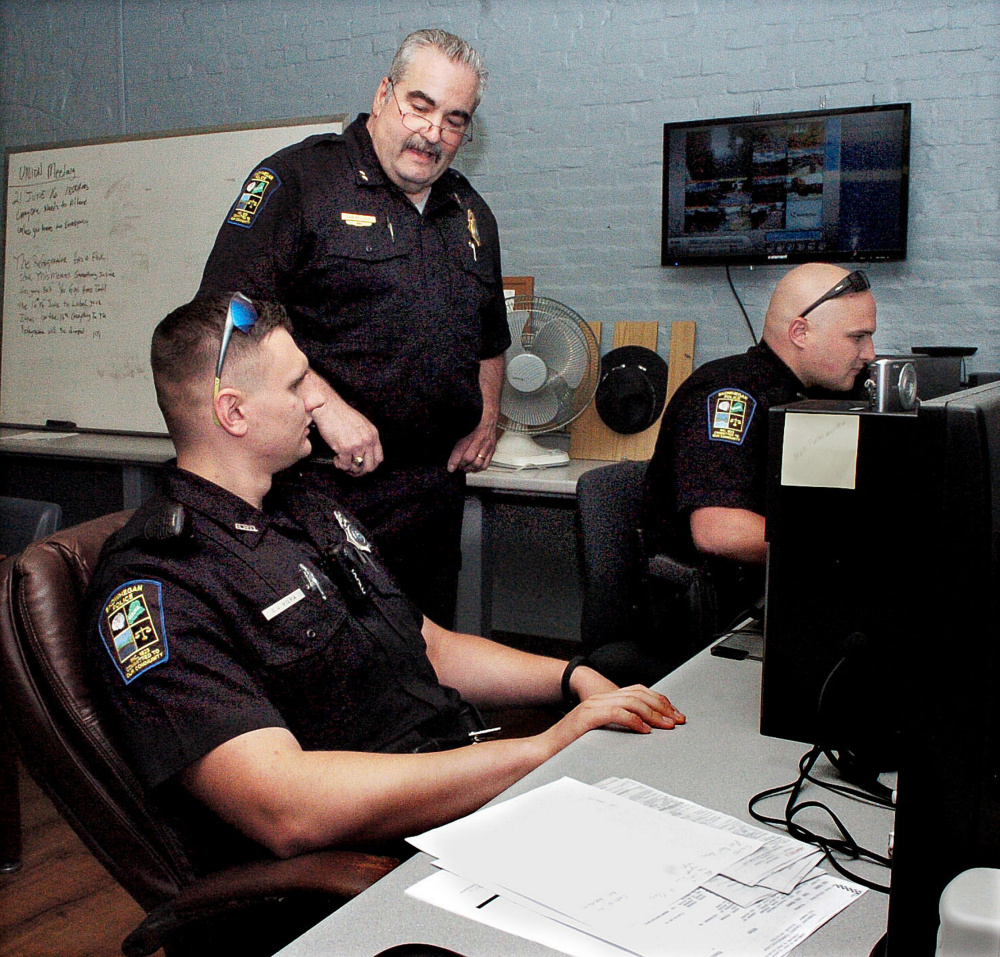 Skowhegan police Chief Don Bolduc, center, oversees officers C.J. Vera, left, and Ian Shalit Wednesday as they fill out police reports at the police station. The department is up to its full compliment of 15 officers for the first time in more than a decade.