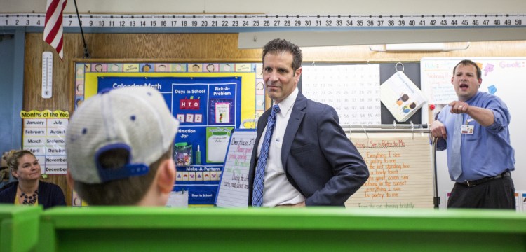 Xavier Botana, the new superintendent of Portland schools, visits a classroom at Hall Elementary School, engaging in a conversation about sports teams with a student, foreground, and assistant principal John Dickerson, far right.