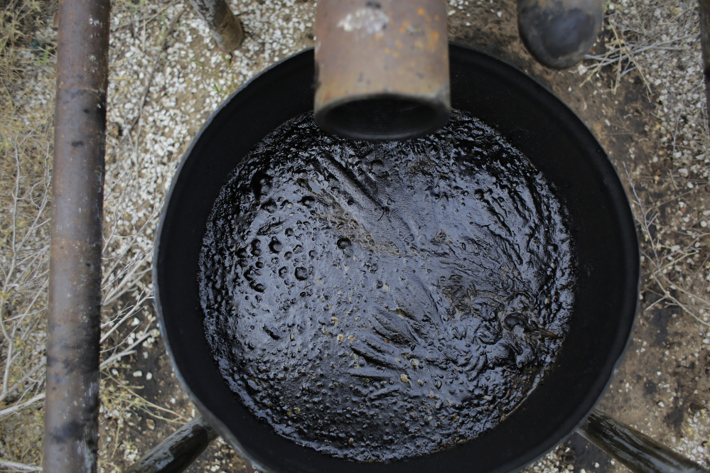 An overflow barrel holds oil near a storage tank on a South Texas ranch near Bigfoot, Texas. The agencies that regulate the oil and gas industry are running out of money just as some problems in the oilfields are worsening. Meanwhile, defunct companies are abandoning wells that are in danger of deteriorating. (AP Photo/Eric Gay)