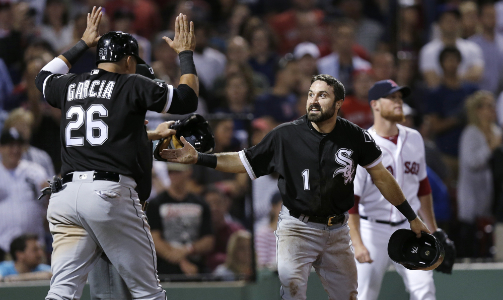 Chicago's Adam Eaton (1) and Avisail Garcia celebrate after both scored on a double by Jose Abreu off Red Sox closer Craig Kimbrel, rear right, in the 10th inning Monday night at Fenway Park. The runs gave the White Sox a 3-1 win, with Kimbrel taking the loss.