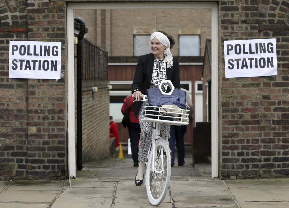 A woman on a bicycle leaves a polling station near to the Royal Chelsea Hospital in London on Thursday. Voters in Britain are deciding Thursday whether the country should remain in the European Union.