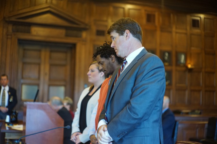 Abil Teshome is flanked by his attorneys, Alison Thompson and Jon Gale, at the Cumberland County Courthouse in Portland Thursday.