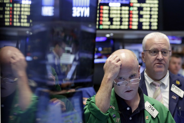Kevin Walsh, second from right, works on the floor of the New York Stock Exchange on Friday. U.S. stocks plunged in early trading after Britons voted to leave the European Union.