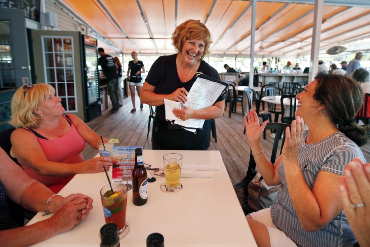 Ann LePage chats with diners after taking their order at McSeagull's restaurant on Thursday in Boothbay Harbor.