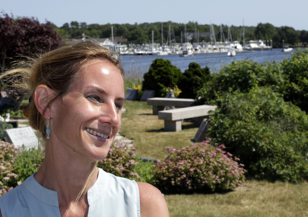 In this Monday, June 20, 2016 photo, Danielle Hetu speaks about the Westerly Yacht Club's membership policy as the yacht club is seen in the background in Westerly, R.I. Wives can join as associate, non-voting members, but unmarried women can't. A vote to change the nearly century-old policy failed last week, with 171 men voting to uphold it. Women, and many men, are not happy. (AP Photo/Elise Amendola)