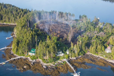 Trees and brush smolder in the middle of Sheep Island on Saturday in Casco Bay after firefighters and forest rangers managed to save 10 cottages from a blaze.