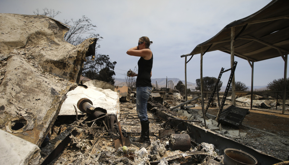 A distraught Amy Nelson goes through the remains of her South Lake, Calif., home Saturday that was devastated by a wildfire.