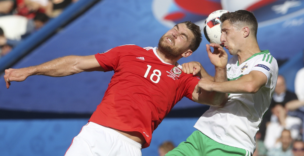 Sam Vokes, left, of Wales and Craig Cathcart of Northern Ireland challenge for the ball during their Round of 16 match Saturday in the European Championships in Paris. Wales, which qualified for a major tournament for the first time since the 1958 World Cup, won 1-0 and will meet Hungary or Belgium in a quarterfinal.
