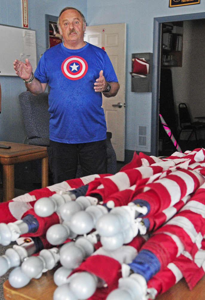 Standing behind a bundle of 20 American flags that had to be removed from Randolph utility poles, Jim Kimball talks about the summer flag program Friday in Randolph.