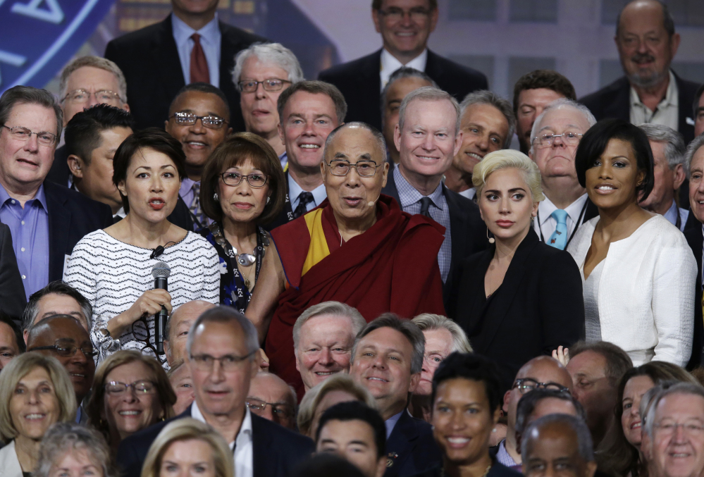 The Dalai Lama and Lady Gaga, center second from right, pose for a photo with mayors attending the U.S. Conference of Mayors in Indianapolis, Sunday, June 26, 2016.