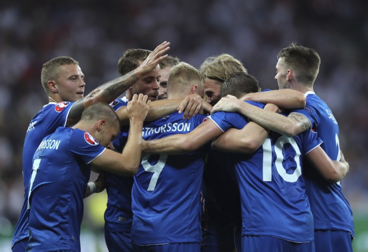 Iceland players celebrate after Kolbeinn Sigthorsson, center, scored the go-ahead goal Monday in a 2-1 victory over England at the European Championships in Nice, France.