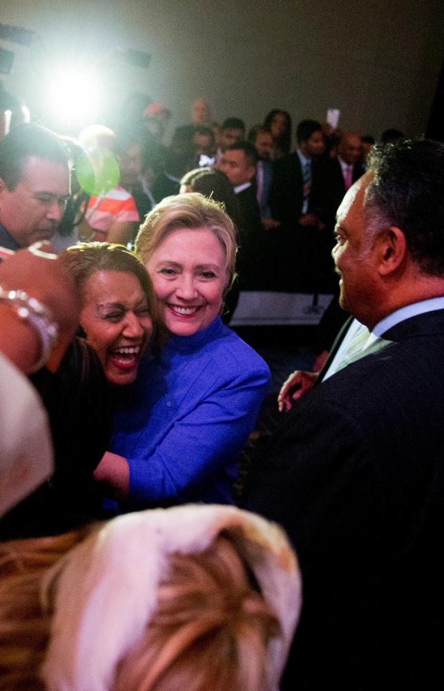 Rev. Jessie Jackson watches as Hillary Clinton hugs a member of the audience after speaking at a Rainbow PUSH Women's International Luncheon on Monday.