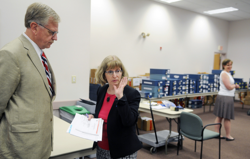 Candidate Mark Holbrook speaks with Deputy Secretary of State Julie Flynn on Tuesday before the beginning of the 1st Congressional District primary race recount in Augusta.