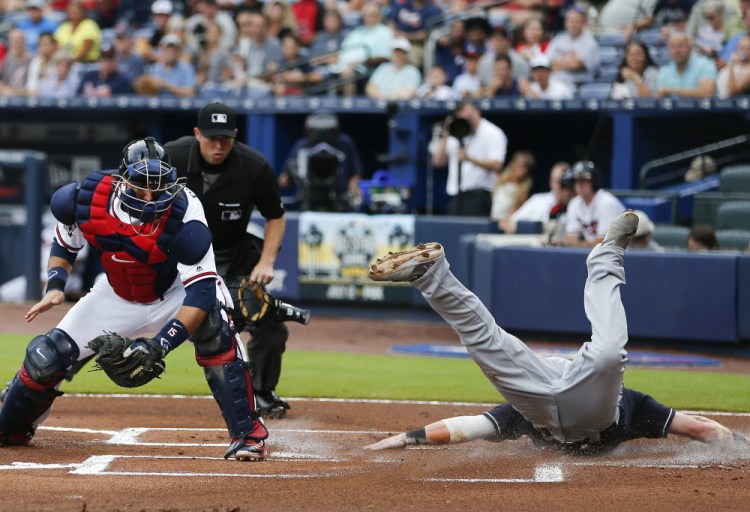 Jason Kipnis of the Indians scores face first ahead of the throw to Braves catcher A.J. Pierzynski on a Jose Ramirez hit in the first inning Tuesday night in Atlanta.