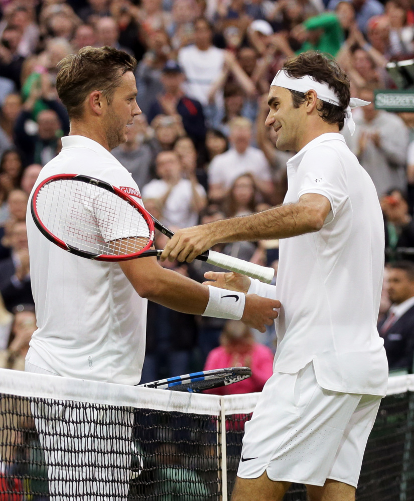 Roger Federer shakes hands with Marcus Willis, left, after beating him in their men's singles match on day three of Wimbledon in London on Wednesday.