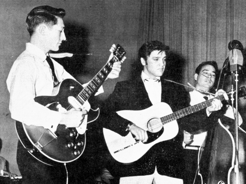 Elvis Presley performs on tour in the summer of 1957, with Scotty Moore on guitar, left, and Bill Black on the standup bass. Moore died at home in Nashville on Tuesday.