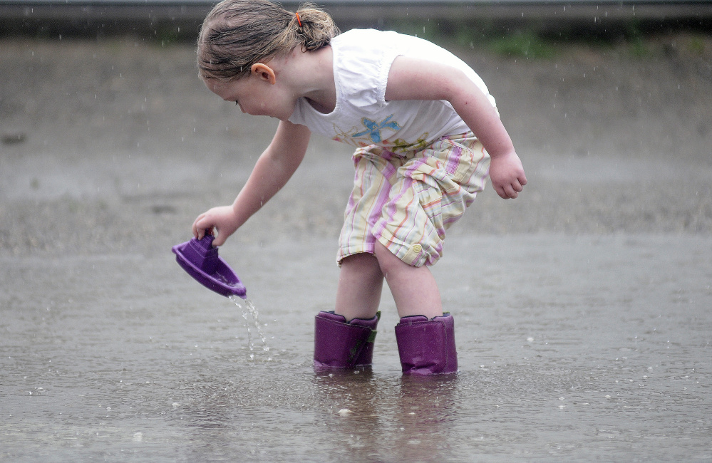 Emily Nichols, 4, launches a plastic boat Wednesday outside her Gardiner home.