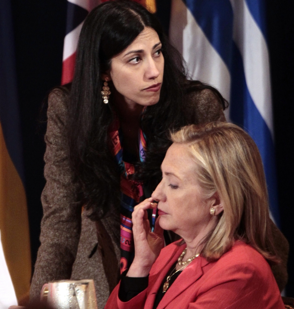 Huma Abedin, deputy chief of staff and aide to then-Secretary of State Hillary Rodham Clinton, confers with her boss.
