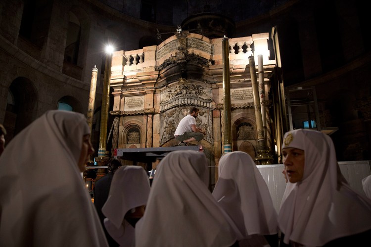 Christian nuns watch as a team of experts begin renovation of Jesus' tomb in the Church of the Holy Sepulchre in Jerusalem's old city on Monday. A team of experts has begun a historic renovation at the spot where Christians believe Jesus was buried, overcoming longstanding religious rivalries to carry out the first repairs at the site in over 200 years. 