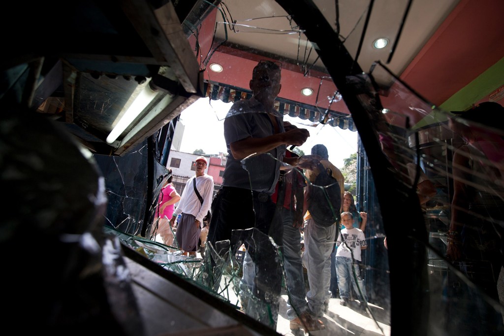 People enter a bakery that was looted the day before in the Petare neighborhood of Caracas, Venezuela, on Friday. In the city's largest slum, dozens of people looted bakeries and food trucks in a spate of food-related violence that has become increasingly common in recent weeks. Bernie Sanders should take note of what is happening in the socialist country, M.D. Harmon writes.
