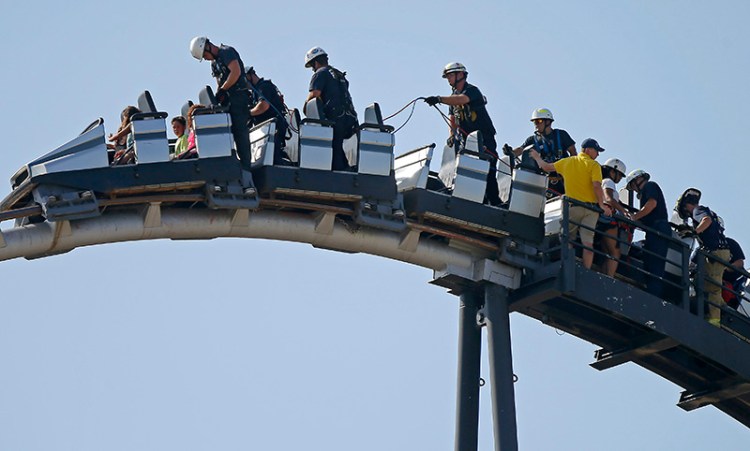 Oklahoma City firefighters rescue amusement park goers stuck on a stalled roller coaster at Frontier City in Oklahoma City on Wednesday, June 29, 2016. (Bryan Terry/The Oklahoman via AP)