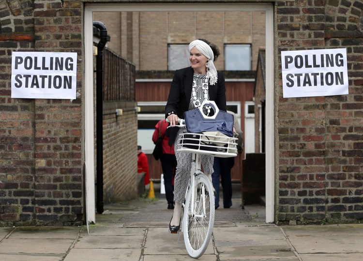 A woman on a bicycle leaves a polling station near to the Royal Chelsea Hospital in London. Voters in Britain are deciding whether the country should remain in the European Union.