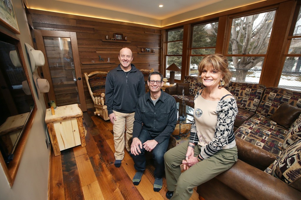 Carl Unger, left, and Nate Tollefson of Craft Design Build with homeowner Caryn Schall in the new year-round room they created in a former three-season porch.