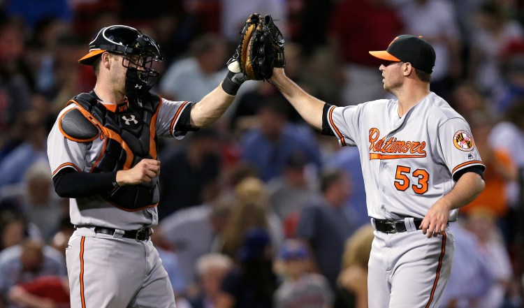 Baltimore closer Zach Britton is congratulated by catcher Matt Wieters after closing out the Orioles' 3-2 win over Boston on Tuesday.   Associated Press/Charles Krupa
