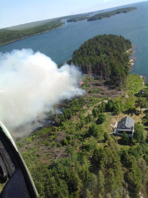 Smoke rises from a fire near a home on Sheep Island off Harpswell on Friday.
