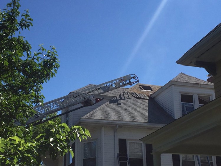 Portland firefighters cut a hole to vent the attic of the house 33 Clifton Street.