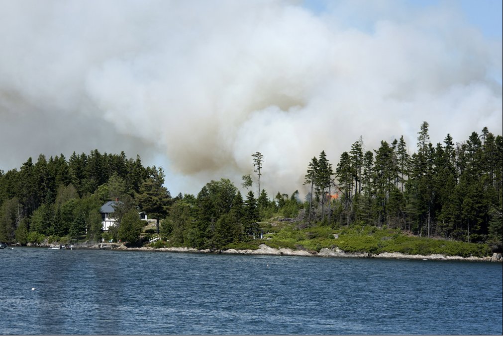 Smoke rises over Sheep Island inn Casco Bay, where about 4 acres burned Friday.
