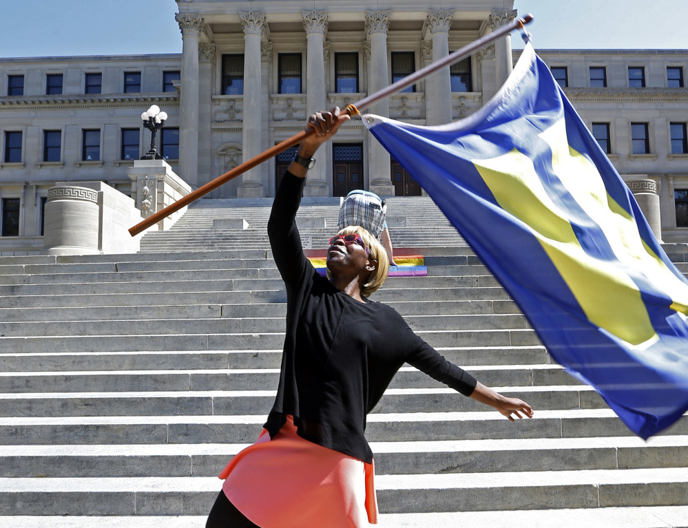 Katherine Day waves the Human Rights Campaign flag at the Mississippi Capitol in Jackson, Miss., on Friday. Gov. Phil Bryant will appeal a recent federal ruling upholding gay marriage.