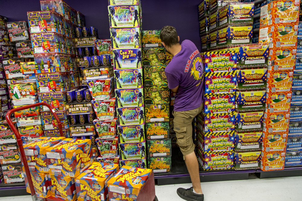 Grant Emrich restocks piles of fireworks at Phantom Fireworks in Scarborough on Friday as customers shop in preparation for Independence Day on Monday.